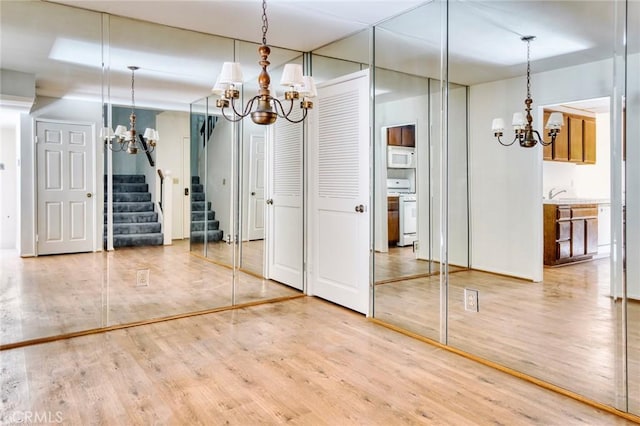 unfurnished dining area with an inviting chandelier and hardwood / wood-style floors