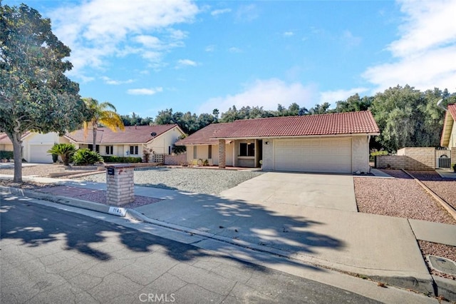 view of front of home featuring fence, concrete driveway, a tiled roof, stucco siding, and a garage