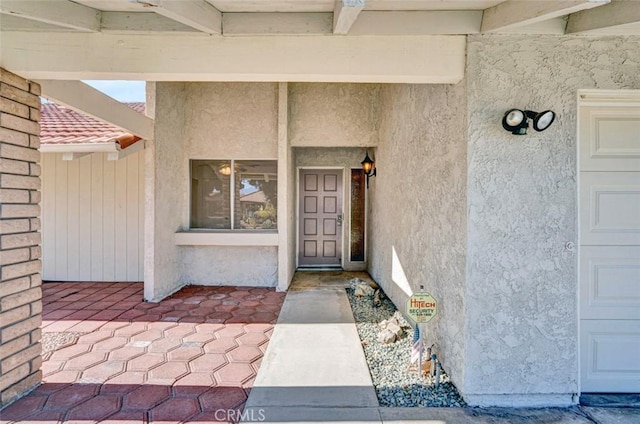 view of exterior entry featuring stucco siding