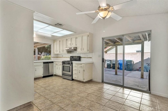 kitchen featuring lofted ceiling, white cabinetry, stainless steel appliances, backsplash, and ceiling fan