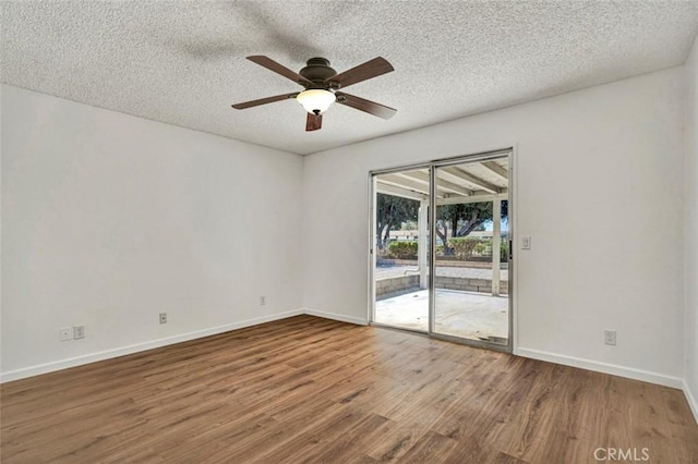 unfurnished room with baseboards, wood finished floors, ceiling fan, and a textured ceiling
