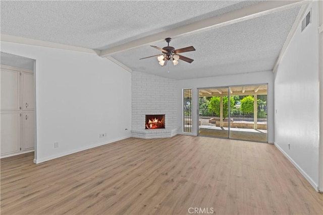 unfurnished living room with a fireplace, a ceiling fan, light wood-style flooring, baseboards, and a textured ceiling