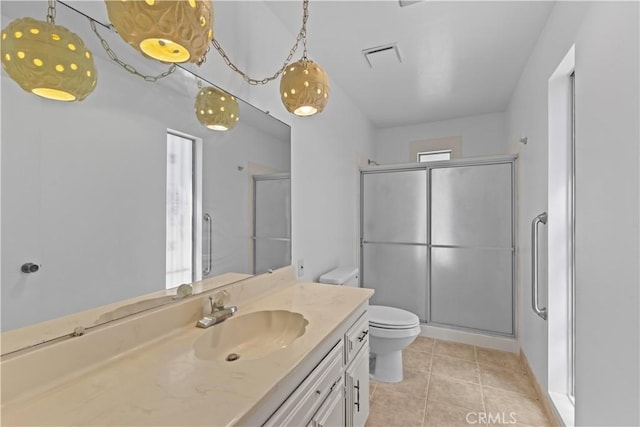 bathroom with a shower stall, visible vents, toilet, vanity, and tile patterned flooring