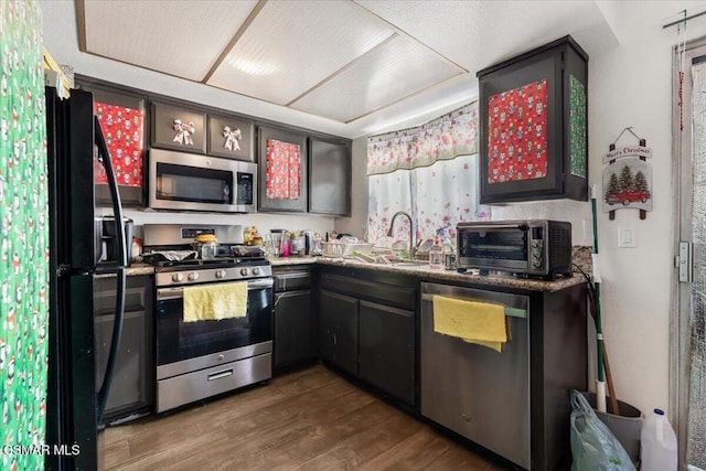 kitchen with dark wood-type flooring, appliances with stainless steel finishes, and sink