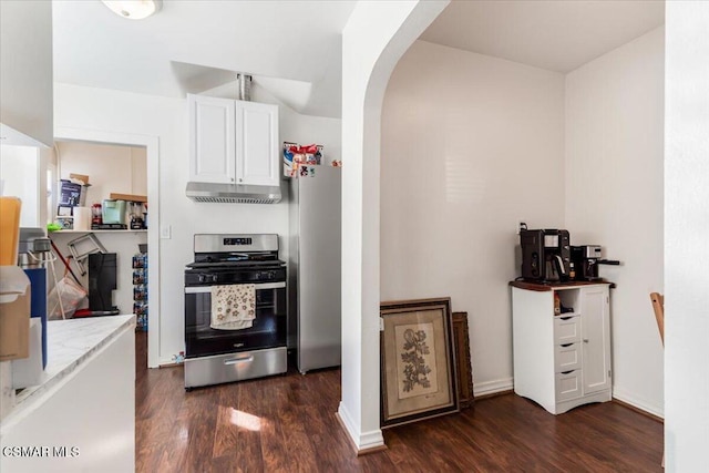 kitchen featuring light stone countertops, white cabinets, appliances with stainless steel finishes, and dark hardwood / wood-style flooring