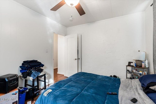 bedroom featuring ceiling fan, hardwood / wood-style floors, and ornamental molding