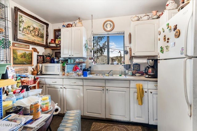 kitchen with white cabinetry, sink, and white appliances