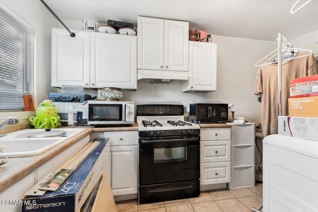 kitchen with sink, white cabinets, black appliances, and light tile patterned flooring