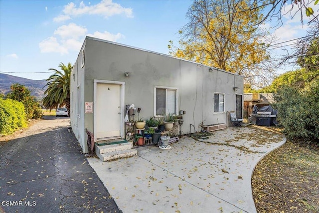 rear view of house with a mountain view and a patio area