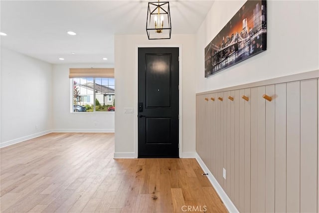 foyer entrance featuring a chandelier and light hardwood / wood-style floors