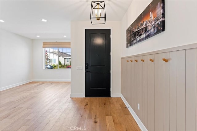 foyer entrance featuring light hardwood / wood-style floors and a notable chandelier