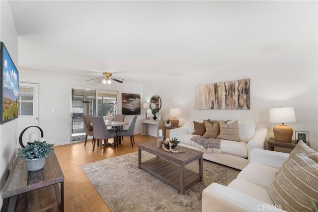 living room featuring ceiling fan and parquet flooring