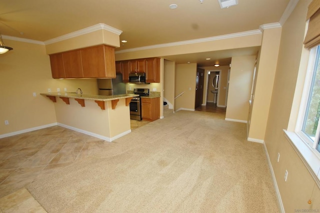 kitchen featuring appliances with stainless steel finishes, a kitchen breakfast bar, kitchen peninsula, light colored carpet, and crown molding