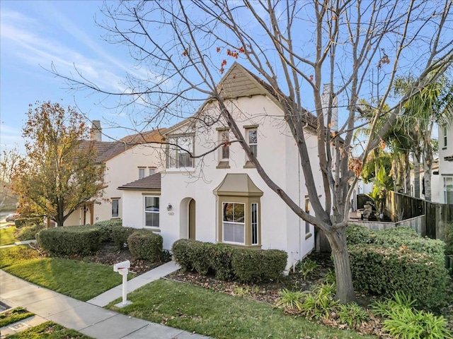 view of front of property with a front yard and a balcony