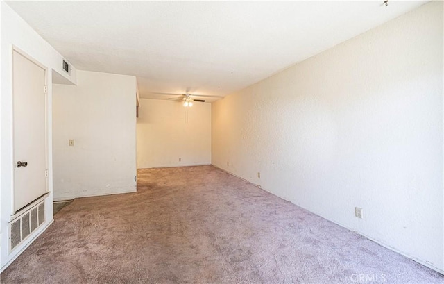 carpeted spare room with ceiling fan