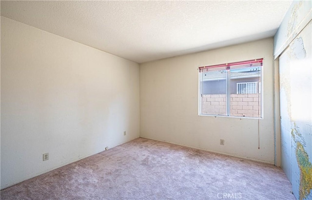 unfurnished room featuring a textured ceiling and carpet floors