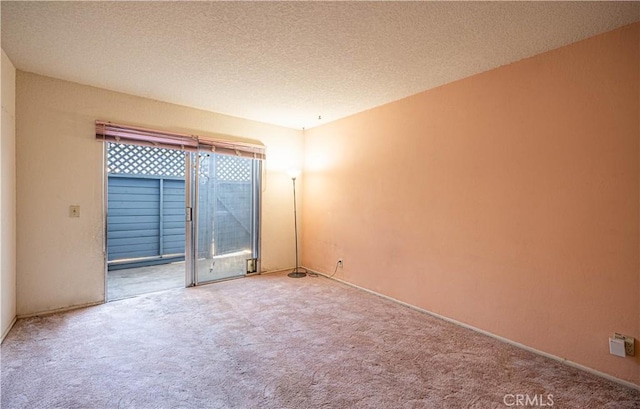 carpeted spare room featuring a textured ceiling