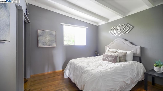 bedroom with dark hardwood / wood-style flooring and vaulted ceiling with beams