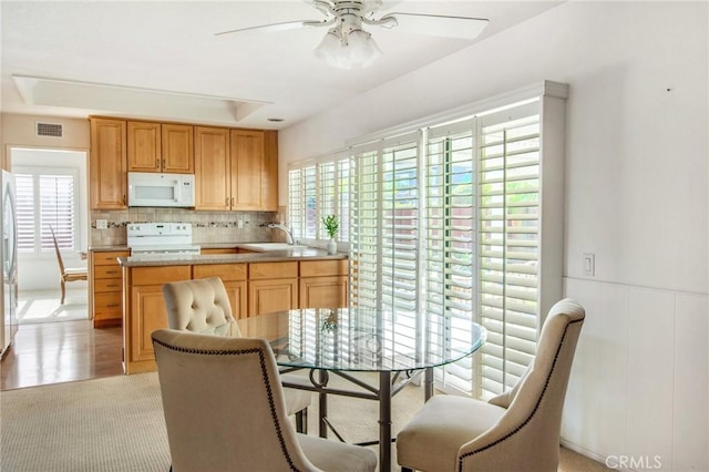 kitchen featuring ceiling fan, a tray ceiling, sink, and white appliances