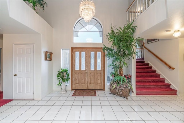 tiled foyer entrance featuring a notable chandelier and a towering ceiling