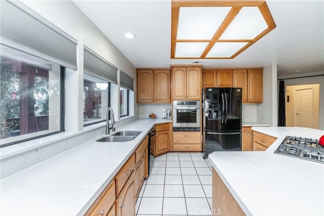 kitchen featuring black appliances, a healthy amount of sunlight, sink, and light tile patterned floors