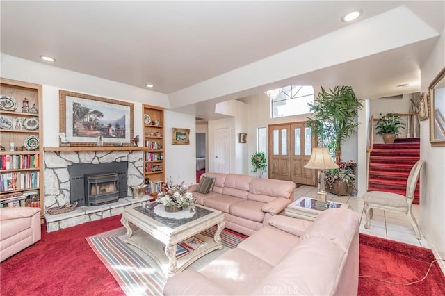 tiled living room with built in shelves and a stone fireplace