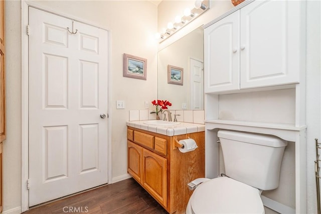 bathroom featuring toilet, vanity, and wood-type flooring