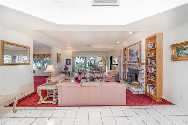 living room featuring light tile patterned floors and a wood stove