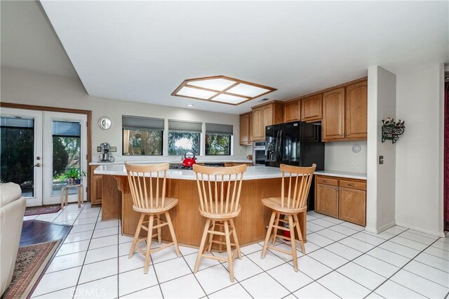 kitchen featuring a kitchen bar, black fridge with ice dispenser, and a kitchen island