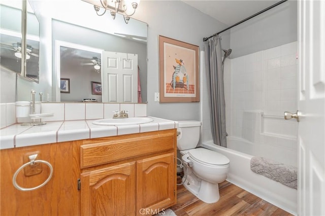 full bathroom featuring toilet, hardwood / wood-style floors, ceiling fan, shower / bath combo, and vanity