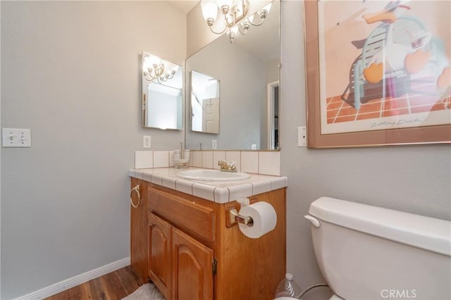 bathroom with toilet, wood-type flooring, and vanity