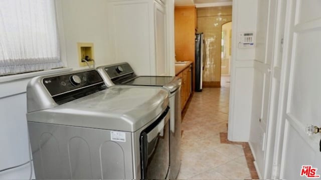 laundry area featuring light tile patterned floors and independent washer and dryer