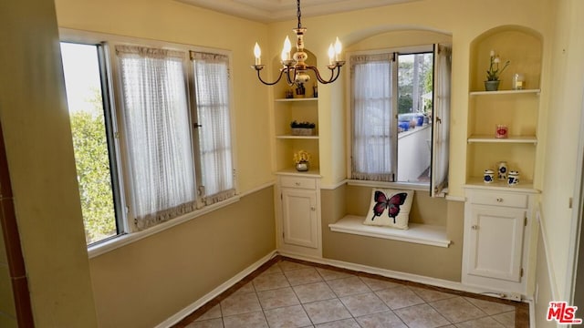 unfurnished dining area with built in shelves, light tile patterned floors, and a chandelier