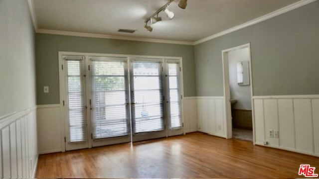 entryway featuring ornamental molding, rail lighting, and light hardwood / wood-style floors