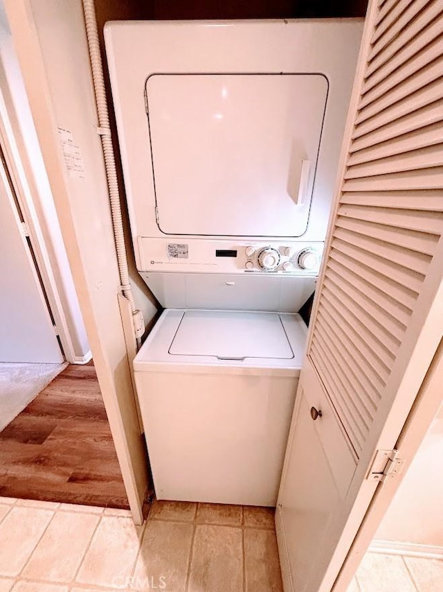 clothes washing area with stacked washer and clothes dryer