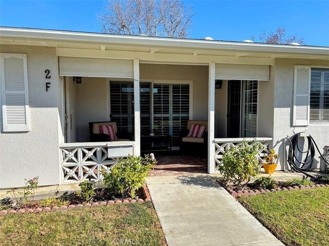 view of exterior entry featuring covered porch