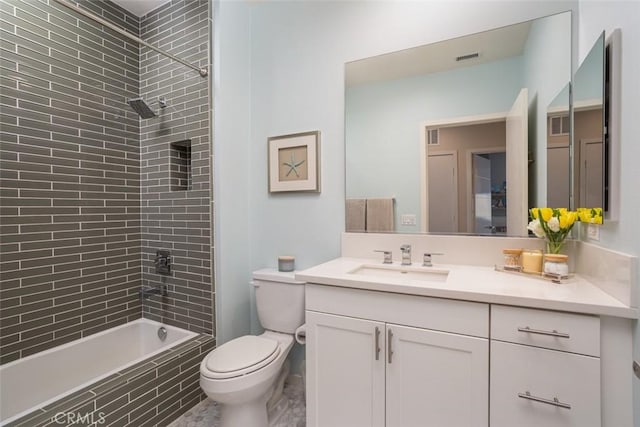 full bathroom with toilet, tiled shower / bath, and vanity