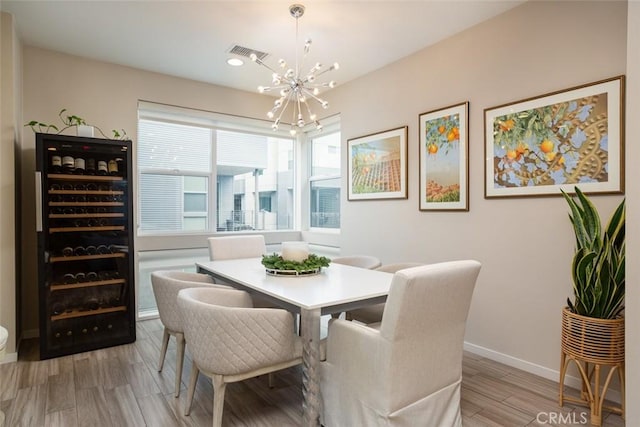 dining area with an inviting chandelier, light hardwood / wood-style floors, and beverage cooler