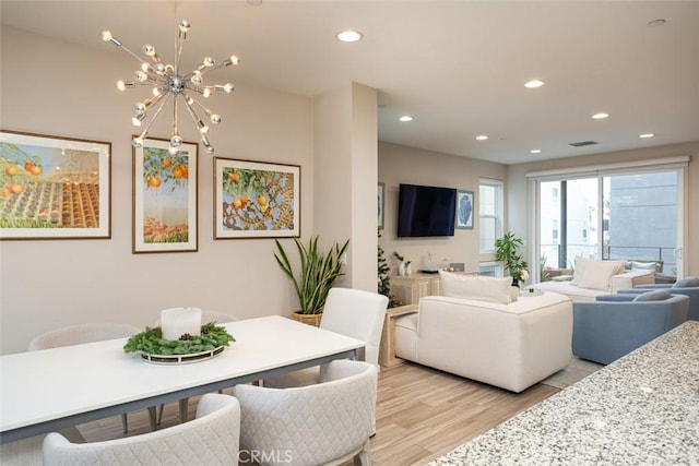 living room featuring an inviting chandelier and light hardwood / wood-style flooring