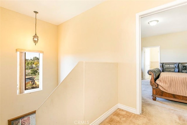 hall with light colored carpet