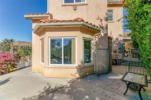 view of side of home with a patio area and a mountain view