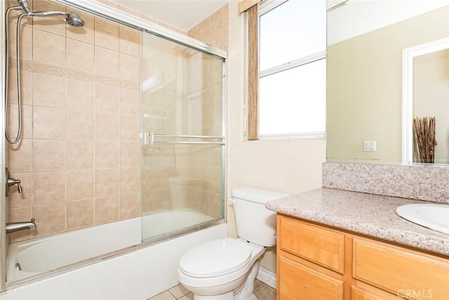 full bathroom with toilet, vanity, tile patterned floors, and bath / shower combo with glass door