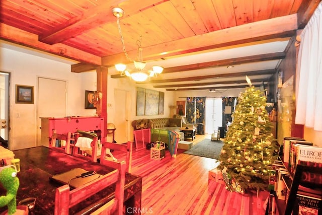 dining space featuring hardwood / wood-style flooring, a notable chandelier, and beamed ceiling