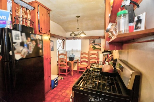 kitchen featuring black refrigerator, gas stove, hanging light fixtures, vaulted ceiling, and a chandelier