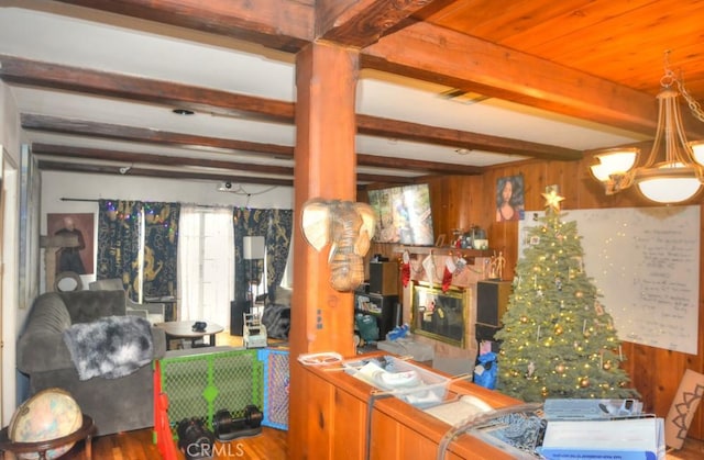 kitchen featuring beamed ceiling, wooden walls, and hardwood / wood-style flooring