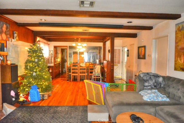 living room with hardwood / wood-style floors, a notable chandelier, and beamed ceiling