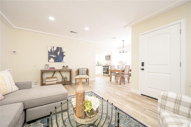 living room featuring an inviting chandelier and light hardwood / wood-style flooring