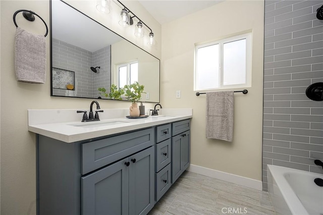 bathroom featuring tiled shower / bath and vanity