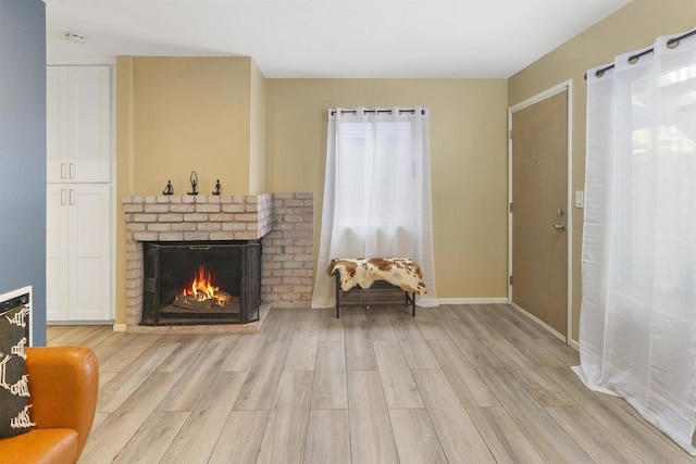 sitting room with light wood-type flooring and a fireplace