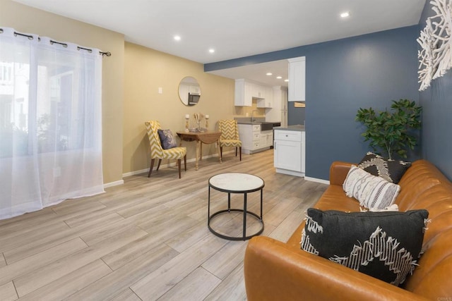 living room with light wood-type flooring and sink